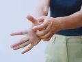 Mano che si gratta il palmo, forse per un fastidioso prurito alle braccia.