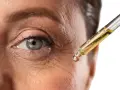 Goccia di siero con retinolo vicino all'occhio per combattere le rughe. Il retinolo cosa serve? A ringiovanire la pelle.
