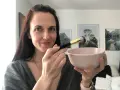 Donna prepara una maschera viso fai da te con bicarbonato, usando un pennello per applicarla.