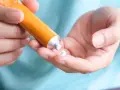 Mano che applica crema al cortisone su un dito, per alleviare la dermatite atopica.
