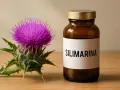 Fiore di cardo e flacone con etichetta "SILIMARINA". Scopri cos'è la silimarina e i suoi benefici.