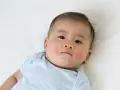 Bambino con guance arrossate e screpolate, forse per la differenza tra dermatite atopica e seborroica.