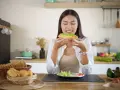 Donna assapora un toast con avocado, un alimento ricco di vitamina E, essenziale per la pelle e il sistema immunitario.