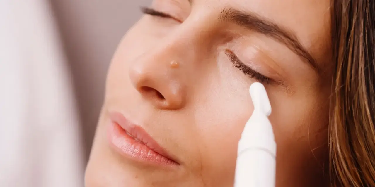 Donna applica siero contorno occhi con un applicatore. Scopri come applicare il siero contorno occhi per un look radioso.