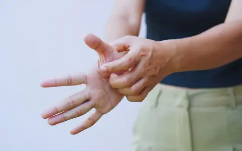 Mano che si gratta il palmo, forse per un fastidioso prurito alle braccia.