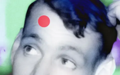 Primo piano di un volto con un punto rosso sulla fronte, come una crosta di brufolo schiacciato. Sfondo astratto verde e viola.