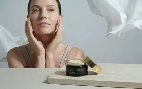 Donna con mani sul viso, vicino a un vasetto di crema. Soluzione per pelle secca viso rimedi.