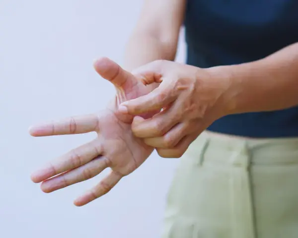 Mano che si gratta il palmo, forse per un fastidioso prurito alle braccia.
