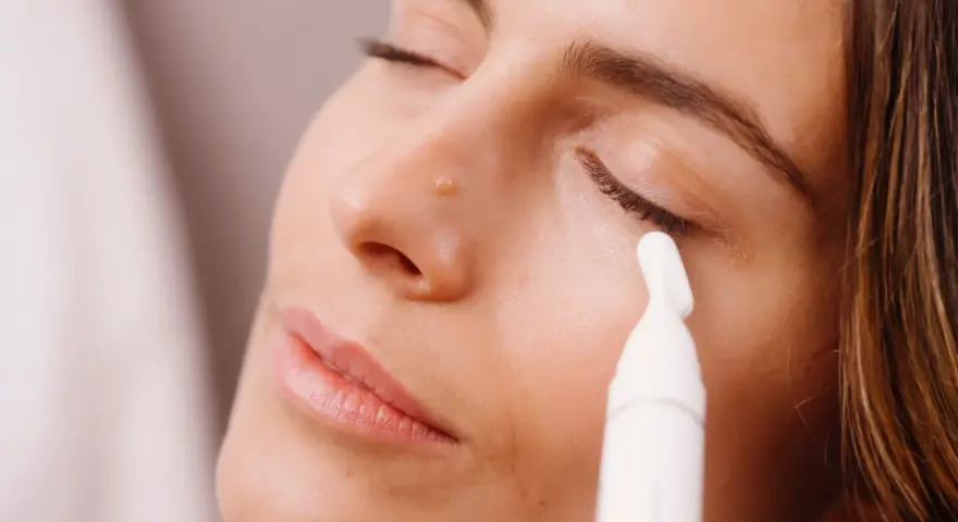 Donna applica siero contorno occhi con un applicatore. Scopri come applicare il siero contorno occhi per un look radioso.