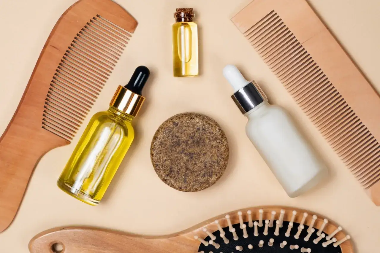 Set per capelli con pettini in legno, oli e una crema. Scopri cos'è il pantenolo per la cura dei capelli.