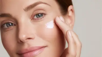 Donna applica crema contorno occhi, contrastando l'invecchiamento precoce a 60 anni. Pelle luminosa e idratata.